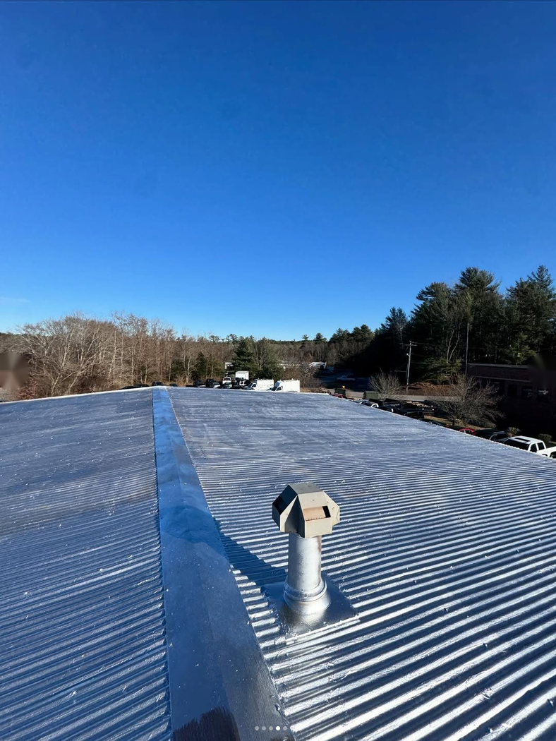 Roofing crew working on a flat roof section